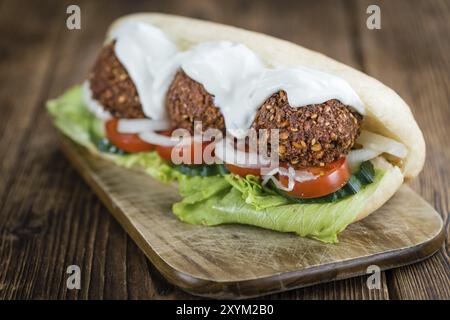 Tavolo in legno con falafel Sandwich appena fatto (messa a fuoco selettiva, foto ravvicinata) Foto Stock