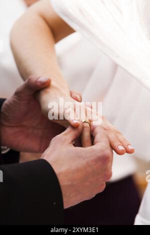 Lo sposo mette l'anello nuziale sul dito della sposa Foto Stock