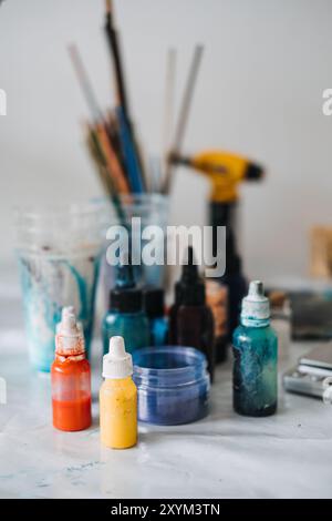 Creazione di vivaci disegni in resina epossidica con vari pigmenti e strumenti in un'area di lavoro fai da te Foto Stock