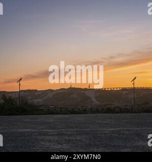 Uomini che corrono su un molo su una spiaggia al tramonto a Espinho, Portogallo, Europa Foto Stock