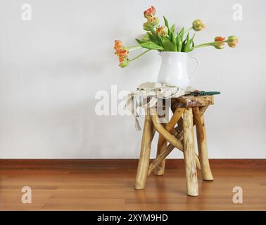 Ancora in vita con i tulipani mazzo di fiori in vaso bianco sul rustico in legno sedia Foto Stock