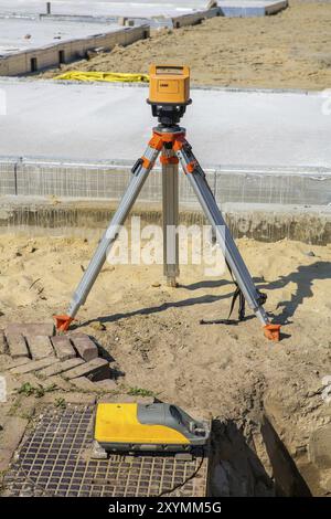 Sito in costruzione con pavimenti in cemento e laser e apparecchiature di misurazione Foto Stock