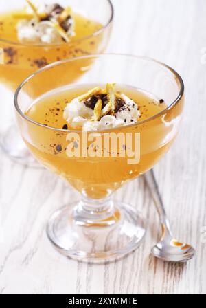 Gelatine di frutta nel recipiente di vetro toped con cioccolato, secche sbucciate e panna montata Foto Stock