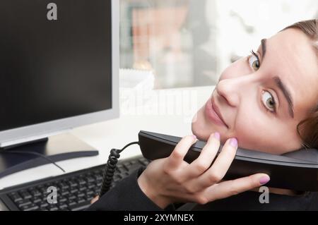 Imprenditrice a parlare al telefono mentre si lavora a un computer Foto Stock