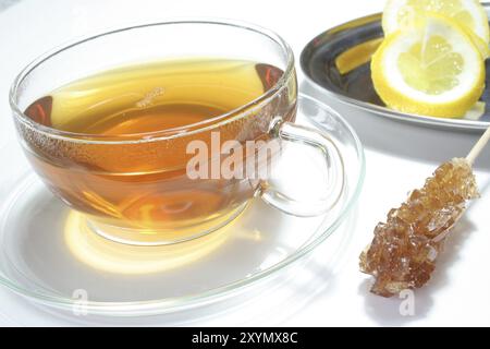 Tè al limone e fette di limone fresche su sfondo bianco Foto Stock