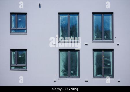 Berlino, Germania. 29 agosto 2024. Foto simbolica sul tema della costruzione di un nuovo appartamento. Quartiere urbano di Buckower Felder nella periferia sud di Berlino. Circa 900 appartamenti sono stati costruiti su un sito di circa 16 ettari. Le lastre di plastica sono appese alle finestre dei nuovi appartamenti quasi finiti. Berlino, 29 agosto 2024. Credito: dpa/Alamy Live News Foto Stock