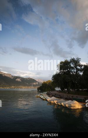 Pedalò coperta per la serata sul lago di Annecy nelle Alpi Foto Stock