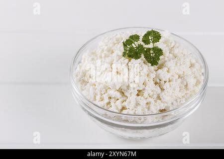 In casa per la ricotta in una ciotola su bianco vecchio tavolo in legno spazio copia Foto Stock