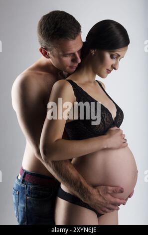 Giovane e bella donna incinta abbraccio. Amore e il concetto di famiglia Foto Stock