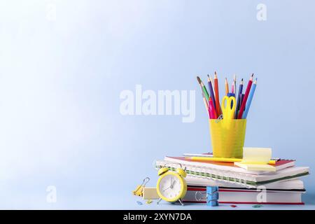 Molte diverse scuole, forniture per ufficio e cancelleria. Concetto di ritorno a scuola. Notebook, libro, penna, matita, forbici, sveglia, orologio, stic Foto Stock