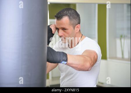 I pugili si sono allenati su un sacchetto di pugni. L'uomo si allena su un sacco da pugni Foto Stock