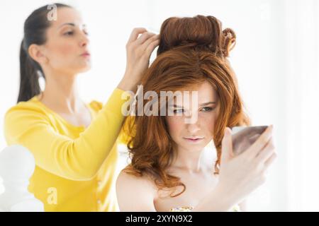 Hair stylist rende la sposa prima del matrimonio Foto Stock