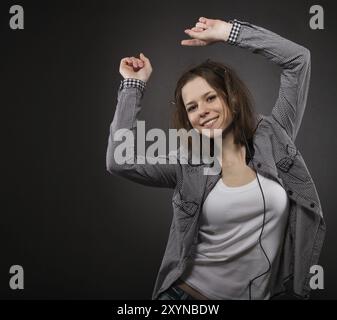 Ritratto di la bruna bellezza ragazza sorridente che indossano le cuffie Foto Stock