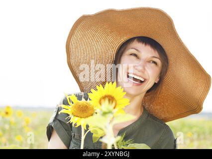 Ritratto di una giovane donna sorridente con girasole nelle giornate di sole Foto Stock