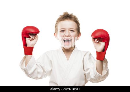 Sport di arte marziale, sorridente campione di karate bambino gesti per il trionfo della vittoria Foto Stock