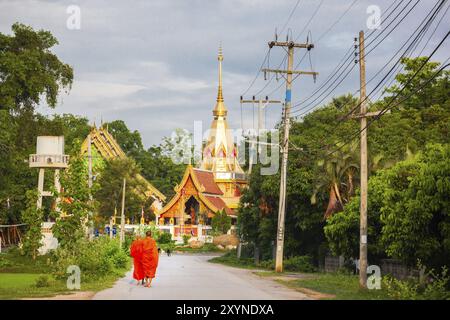 Monaci buddisti che tornano al tempio la mattina dopo aver ricevuto offerte alimentari Foto Stock