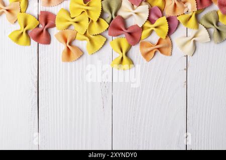 Italiano farfalle colorate pasta bianca su sfondo di legno Foto Stock