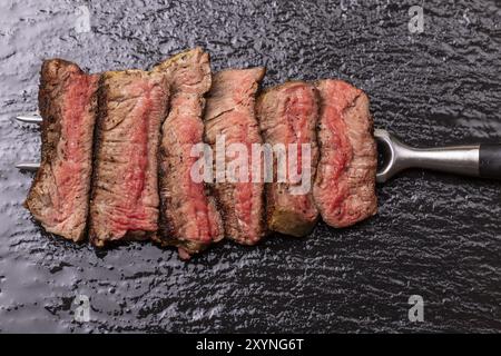 Fette di bistecca su una forchetta Foto Stock