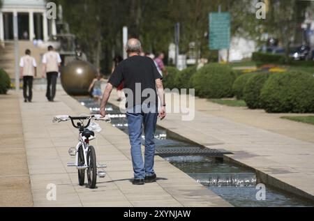 Nonno con la bici di suo nipote, che preferisce giocare da qualche altra parte! Foto Stock