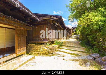 Una serie di case bucoliche in legno e strade sterrate restaurate a un'antica sensazione di campagna giapponese lungo il percorso Nakasendo nel villaggio di Tsumago su una S. Foto Stock