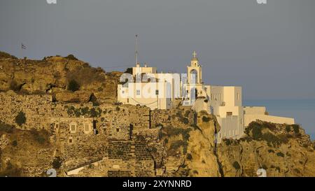 Un castello e edifici bianchi su una scogliera, illuminati dalla luce dorata dell'alba con il mare sullo sfondo, la luce mattutina, Panagia Spiliani, Cast Foto Stock