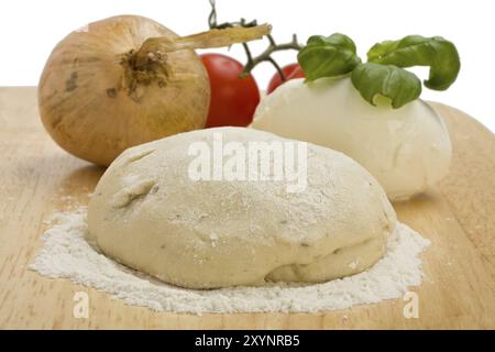 Impasto di lievito, formaggio, pomodori e cipolla su un asse di legno Foto Stock