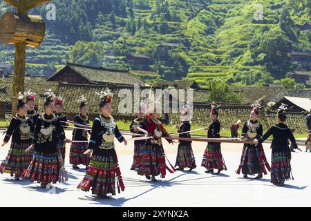 Xijiang, Cina, 15 settembre 2007: Le donne Miao usano un nastro e ballano indossando regalia tradizionali e costumi colorati a Xijiang etnico Foto Stock