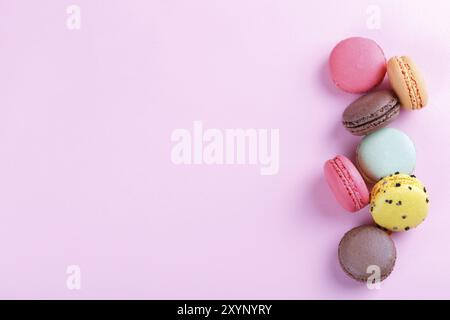 Colorati macarons francese su sfondo rosa con copia spazio, traditioanal dessert in Francia Foto Stock