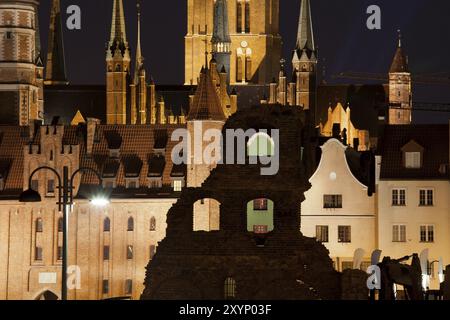 Città vecchia di notte nella città di Danzica, Polonia, architettura storica della chiesa e porta di Santa Maria, case borghesi con tetti spioventi e vecchi resti di granai, Europ Foto Stock