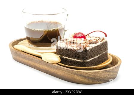 Torta al cioccolato e una tazza di caffè in un vassoio di legno su sfondo bianco Foto Stock