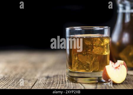 Fresche fatte peach ice tea (messa a fuoco selettiva) su un vecchio tavolo di legno (close-up shot) Foto Stock