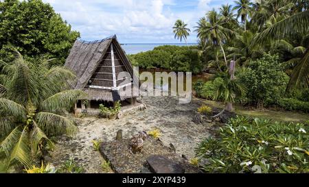 Tradizionale casa storica per gli uomini Tribal Chief Men's House tra palme, sullo sfondo dell'Oceano Pacifico, Yap Island, Yap State, Foto Stock