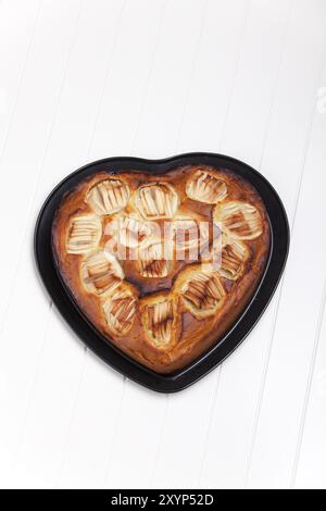 Torta di mele a forma di cuore su bianco Foto Stock