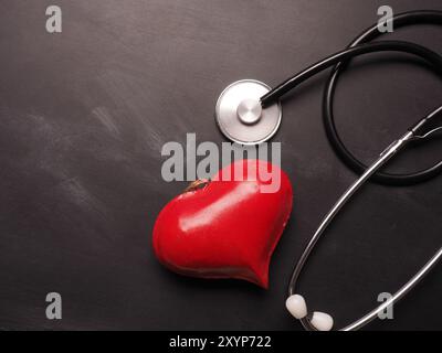 Cuore rosso forma con uno stetoscopio su una lavagna con spazio per il testo Foto Stock