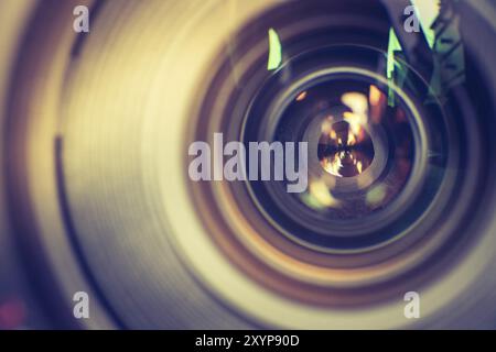 Il fotografo ha in mano un'ottica fotografica professionale. Notebook con sfondo sfocato Foto Stock