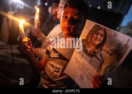 Gaza, Striscia di Gaza, Palestina. 11 maggio 2022. I palestinesi prendono parte a una veglia con le candele accese a Gaza City, per denunciare l'uccisione del giornalista di al-Jazeera Shireen Abu Aqleh. Il giornalista è morto all'inizio di mercoledì dopo essere stato colpito alla testa dalle truppe israeliane durante un raid israeliano nel campo profughi di Jenin in Cisgiordania Foto Stock