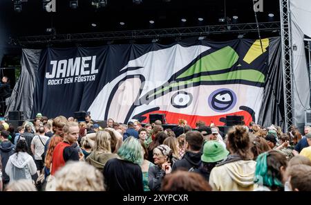 Jamel, Germania. 30 agosto 2024. I visitatori si fermano di fronte al palco il primo giorno del festival "Jamel Rocckt den Förster". Credito: Markus Scholz/dpa/Alamy Live News Foto Stock