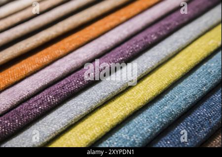 Campioni di tessuti colorati e luminosi di mobili e rivestimenti di abbigliamento. Primo piano di una tavolozza di strisce astratte tessili di diversi colori Foto Stock