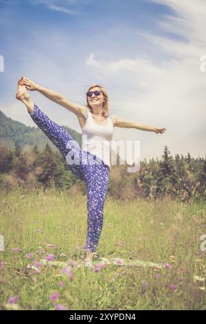 La giovane ragazza sta facendo yoga nel parco Foto Stock