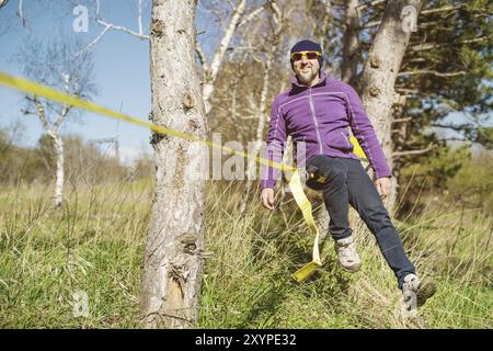 Un uomo all'età di sedersi su una linea lenta, trovare equilibrio e godersi la vita Foto Stock