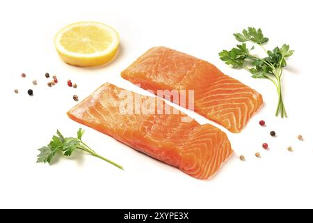 Una foto di due fette di Salmone con limone e pepe e prezzemolo, su sfondo bianco con copia spazio. Messa a fuoco selettiva Foto Stock