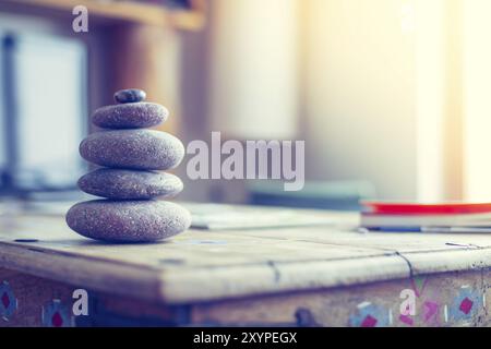 Feng Shui: Cairn di pietra in primo piano, salotto sfocato sullo sfondo. Equilibrio e relax Foto Stock