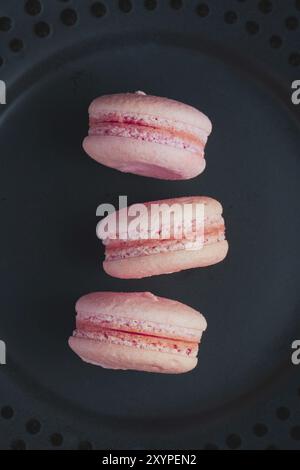 Dolci macaron francesi su sfondo scuro Foto Stock