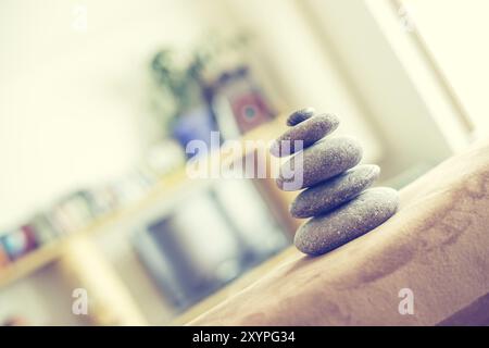 Feng Shui: Cairn di pietra in primo piano, salotto sfocato sullo sfondo. Equilibrio e relax Foto Stock