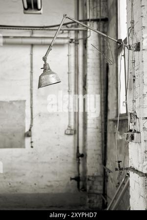 Lampada sul luogo di lavoro in una fabbrica in disuso Foto Stock