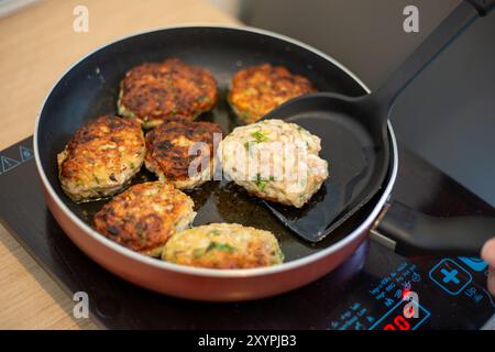 Cucinare. La padella si trova sul piano cottura a induzione, in cui vengono fritte le polpette di carne. Foto Stock