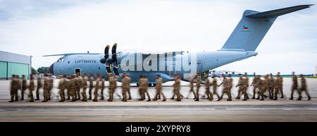 Wunstorf, Germania. 30 agosto 2024. I soldati della Bundeswehr camminano di fronte a un aeromobile da trasporto Airbus A400M presso la base aerea di Wunstorf nella regione di Hannover come parte di una telefonata di ritorno in serata (foto con un lungo tempo di esposizione). La Bundeswehr ha terminato la sua missione in Niger in Africa occidentale e ha lasciato la sua base di trasporto aereo a Niamey. Crediti: Moritz Frankenberg/dpa/Alamy Live News Foto Stock