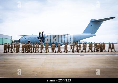 Wunstorf, Germania. 30 agosto 2024. I soldati della Bundeswehr camminano di fronte a un aeromobile da trasporto Airbus A400M presso la base aerea di Wunstorf nella regione di Hannover come parte di una telefonata di ritorno in serata (foto con un lungo tempo di esposizione). La Bundeswehr ha terminato la sua missione in Niger in Africa occidentale e ha lasciato la sua base di trasporto aereo a Niamey. Crediti: Moritz Frankenberg/dpa/Alamy Live News Foto Stock