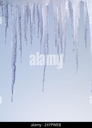 Ghiaccioli di fusione isolati su fondo azzurro Foto Stock