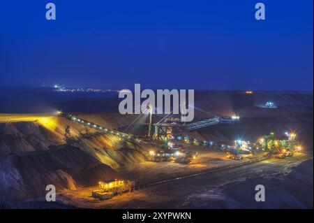 Impilatore e nastro trasportatore in miniera aperta, ripresa notturna Foto Stock